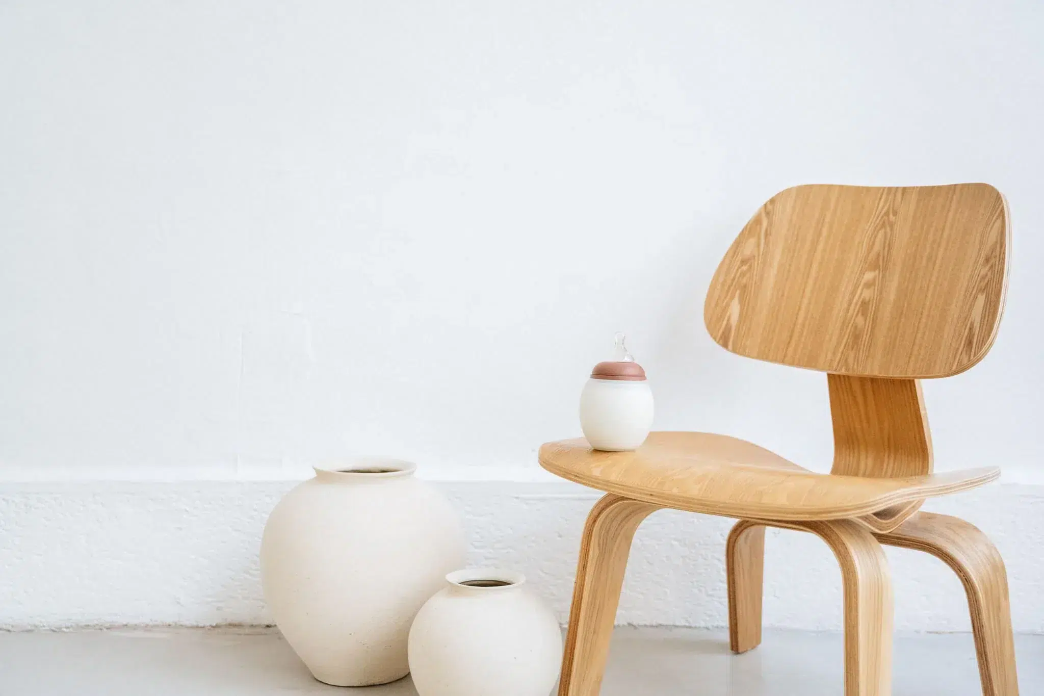 Biberon Elhée présenté sur une chaise en bois design